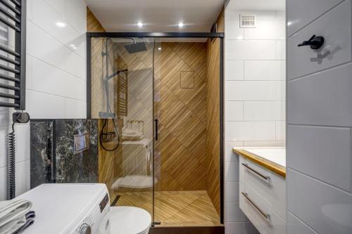 格丁尼亚Apartament Panorama的浴室里设有玻璃门淋浴