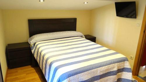 穆罗斯Casa da Mirina Casita para 2的一间卧室配有带条纹毯子的床