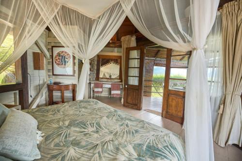黑河区Harmonie的一间卧室配有一张带窗帘的床和一张书桌