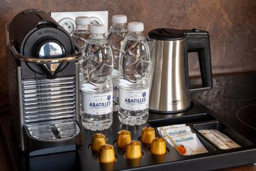 卡普费雷Domaine du Ferret Restaurant & Spa的配有瓶装水和搅拌机的柜台