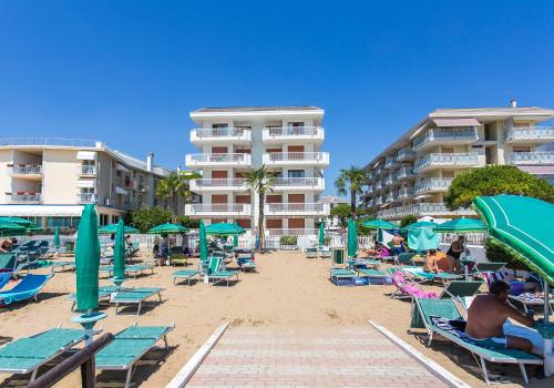 利多迪耶索罗Appartamento Nautilus的一个带椅子和遮阳伞的海滩和一些酒店