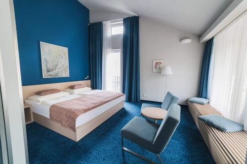 卡丹Hotel Split的蓝色卧室,配有床和椅子