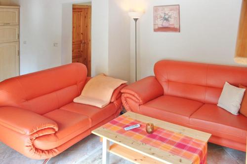 吕本瑙Ferienhaus Herz的客厅配有2张橙色沙发和咖啡桌