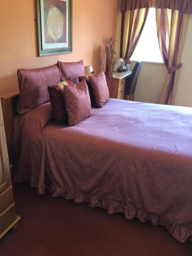 Castle EdenThe Ship inn的一间卧室配有一张带紫色床单的床和窗户。