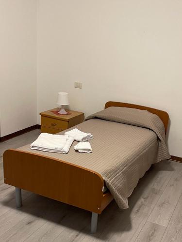 莱诺Albergo Civico 7的一张床位,位于一个配有床头柜和一张四柱床的房间里