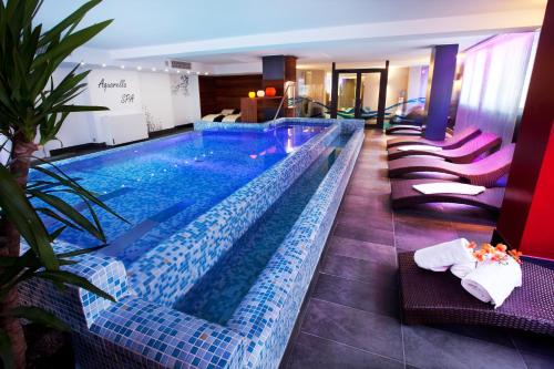 安道尔城阿克塔艺术酒店的紫色和蓝色瓷砖的酒店游泳池