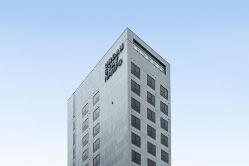 釜山Urbanstay Boutique Nampo BIFF的一座高大的灰色建筑,上面有“树皮”字样
