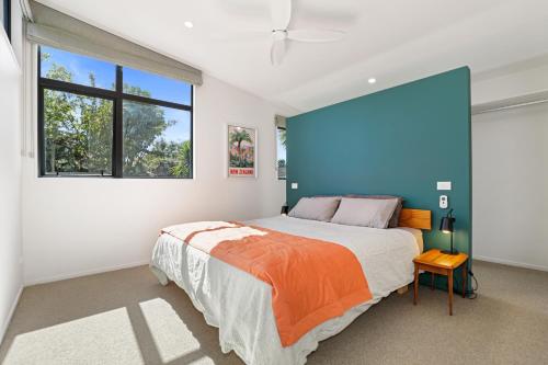 罗托鲁瓦Hannah's Bay Hideaway的一间卧室设有一张大床和蓝色的墙壁