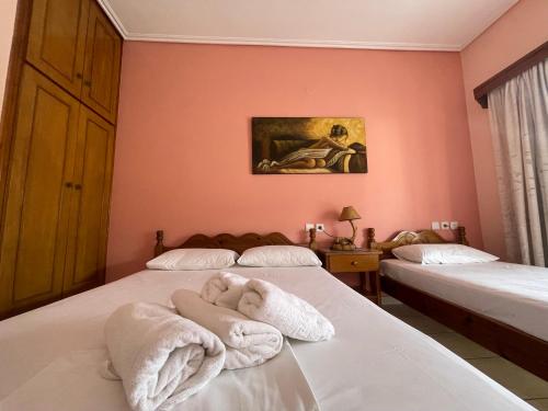 卡拉内拉Diamantoula Rooms的一间卧室配有两张带毛巾的床