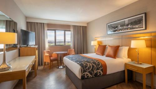 克劳道金克拉尔特昂里弗艾山谷酒店的酒店客房配有一张床、一张书桌和一台电视。