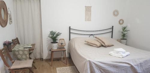 MonterosiIL GIARDINETTO di Dilyana的卧室配有1张床、1张桌子和1把椅子