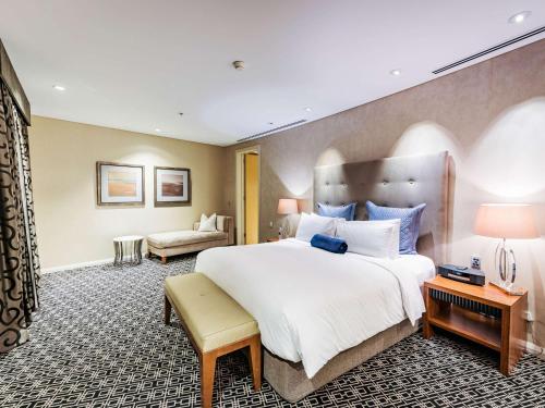 悉尼索菲特悉尼温特沃什酒店的一间带大床的卧室和一间客厅