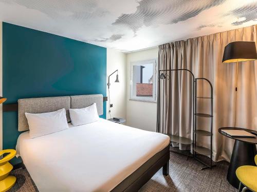 维拉德塞斯宜必思巴塞罗那维拉德坎斯机场酒店的卧室配有一张白色大床和蓝色的墙壁