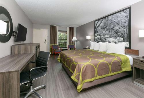 比洛克西比洛克西/ 戴博维勒速8酒店的配有一张床和一张书桌的酒店客房