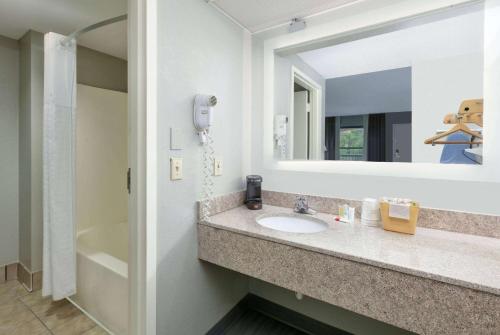 比洛克西比洛克西/ 戴博维勒速8酒店的一间带水槽和镜子的浴室