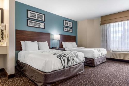 约翰逊城约翰逊城司丽普套房酒店的酒店客房设有两张床和窗户。