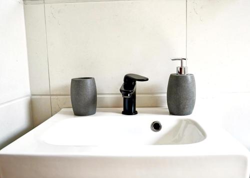 阿吉亚特拉萨Electra apartment Agia Triada的浴室水槽配有水龙头和2杯