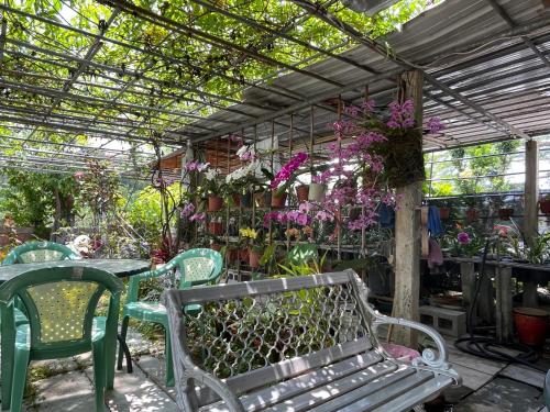 Minxiong旺来庭园民宿的温室,有长凳,桌子和鲜花