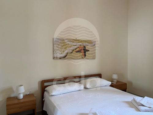 切萨雷奥港Villetta il Veliero的卧室配有一张床,墙上挂有绘画作品