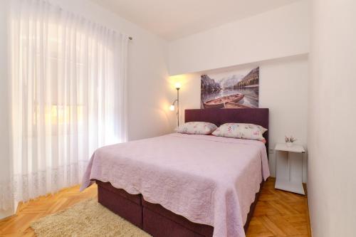 木洛希尼SNJEŽANA的一间卧室配有一张带粉色毯子的大床