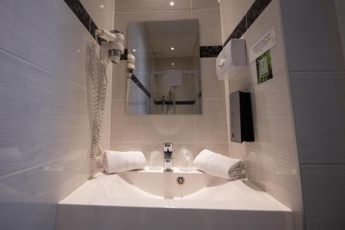 沙托鲁欧陆之家客栈的浴室设有白色水槽和镜子