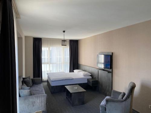 吉拉克Pin Suite Hotel的一间酒店客房,配有一张床和一台电视