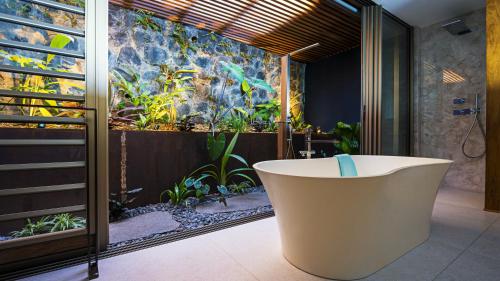 圣勒蓝色马古拉特海景酒店 - 罗莱夏朵精品酒店集团的带浴缸的浴室和花园