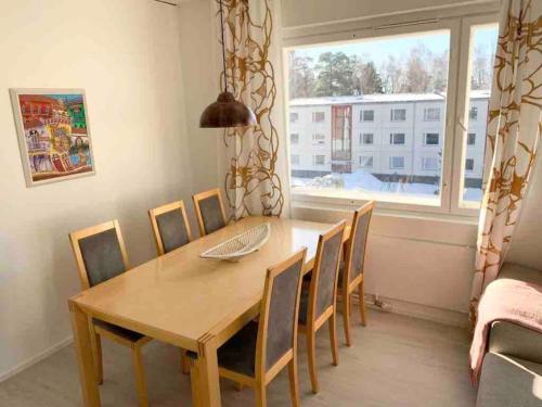 赫尔辛基MELLUNMAKI Renovated 3 bedroom apt next to metro的一间带桌椅和窗户的用餐室