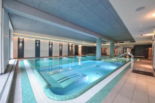 埃尔布隆格Hotel Młyn Aqua Spa Biblioteka的大楼内的大型游泳池