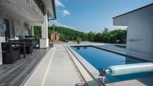 TrebnjeResort TimAJA - pool, massage pool, sauna的一座带房子的建筑旁边的游泳池