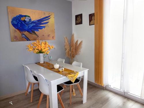 佩皮尼昂Chic et douillet的白色的餐桌、椅子和蓝色的鸟画