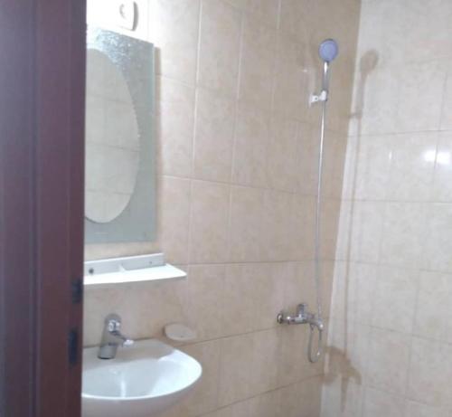 基加利THE PILLAR MOTEL的浴室配有盥洗盆和带镜子的淋浴