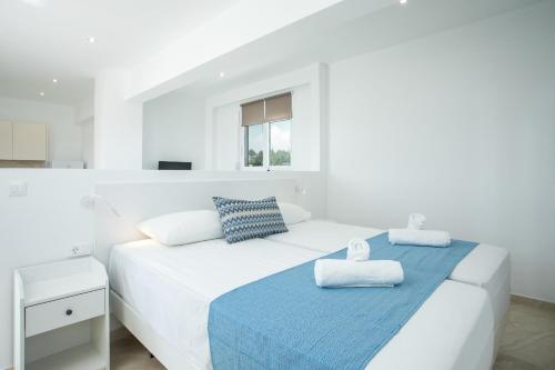 法里拉基VOULA APARTMENTS的白色卧室,配有带毛巾的床