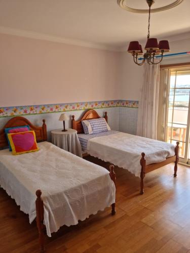 费拉古多Serra e Mar Ferragudo的一间卧室设有两张床、一张桌子和一个窗口