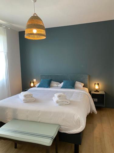 布雷叙尔Le Cinquième的一间卧室配有一张大床和毛巾