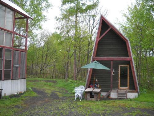 二世古二世古白熊山林小屋的小屋配有桌子和雨伞