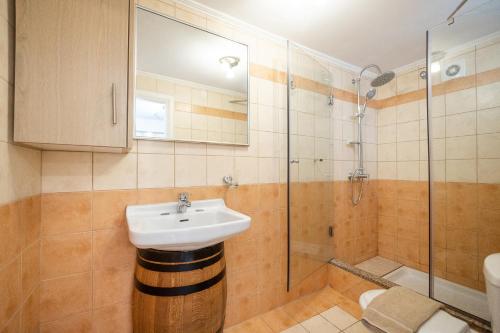 古维亚Mathraki Resort的一间带水槽和淋浴的浴室