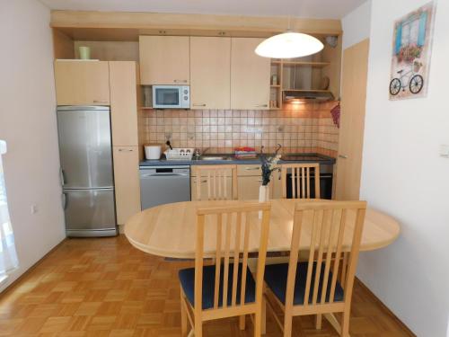 卢布尔雅那Apartment Riverside的厨房配有桌椅和冰箱。