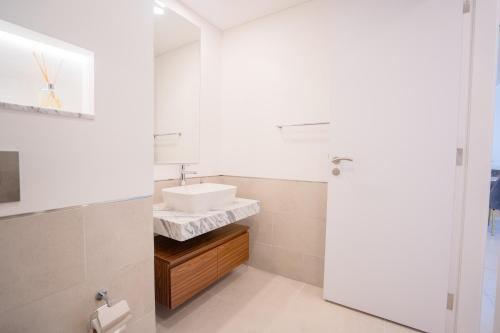 迪拜Nasma Luxury Stays - Fancy Apartment With Balcony Close To MJL's Souk的白色的浴室设有水槽和镜子