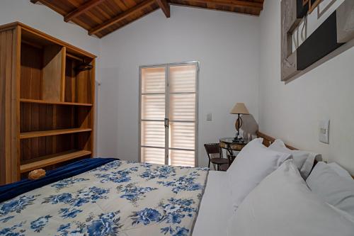 布罗塔斯Hotel Chalés Cachoeira 3 Quedas的一间卧室配有一张床、一张桌子和一个窗户。