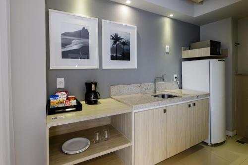 里约热内卢Promenade Link Stay Barra da Tijuca的厨房配有带水槽的柜台和冰箱。