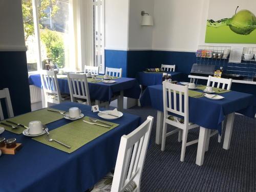 尚克林圣莱昂纳茨旅馆的用餐室配有蓝色桌子和白色椅子