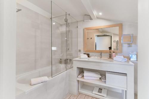 比达尔凯旋门别墅酒店的白色的浴室设有水槽和淋浴。