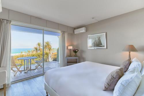 比达尔凯旋门别墅酒店的一间卧室配有一张床,享有海景