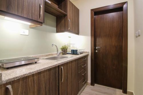 安曼46 Serviced Apartments的一个带水槽和木门的厨房