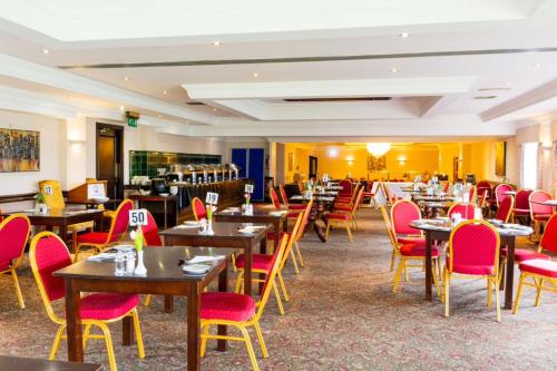 彼得黑德沃特赛德酒店的餐厅设有木桌和红色椅子