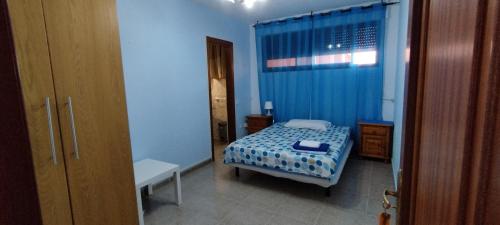 阿罗纳Los Cristianos centro, room with a private bathroom in shared apartment的蓝色客房中一间带床的卧室