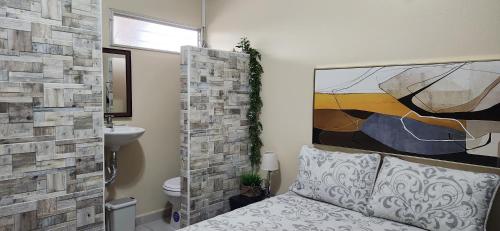 圣佩德罗苏拉Casa Altamira的浴室设有一张床,墙上挂有绘画作品