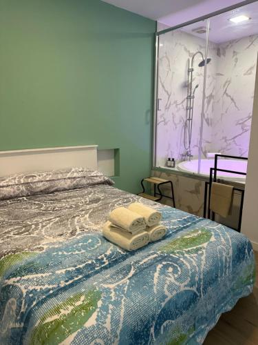 马德里Apartamentos Aguacate的一间卧室配有一张带两条毛巾和浴缸的床。
