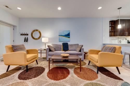 华盛顿Luxe Townhouse Flat in Hip Neighborhood, Near Metro的客厅配有两把椅子和一张沙发